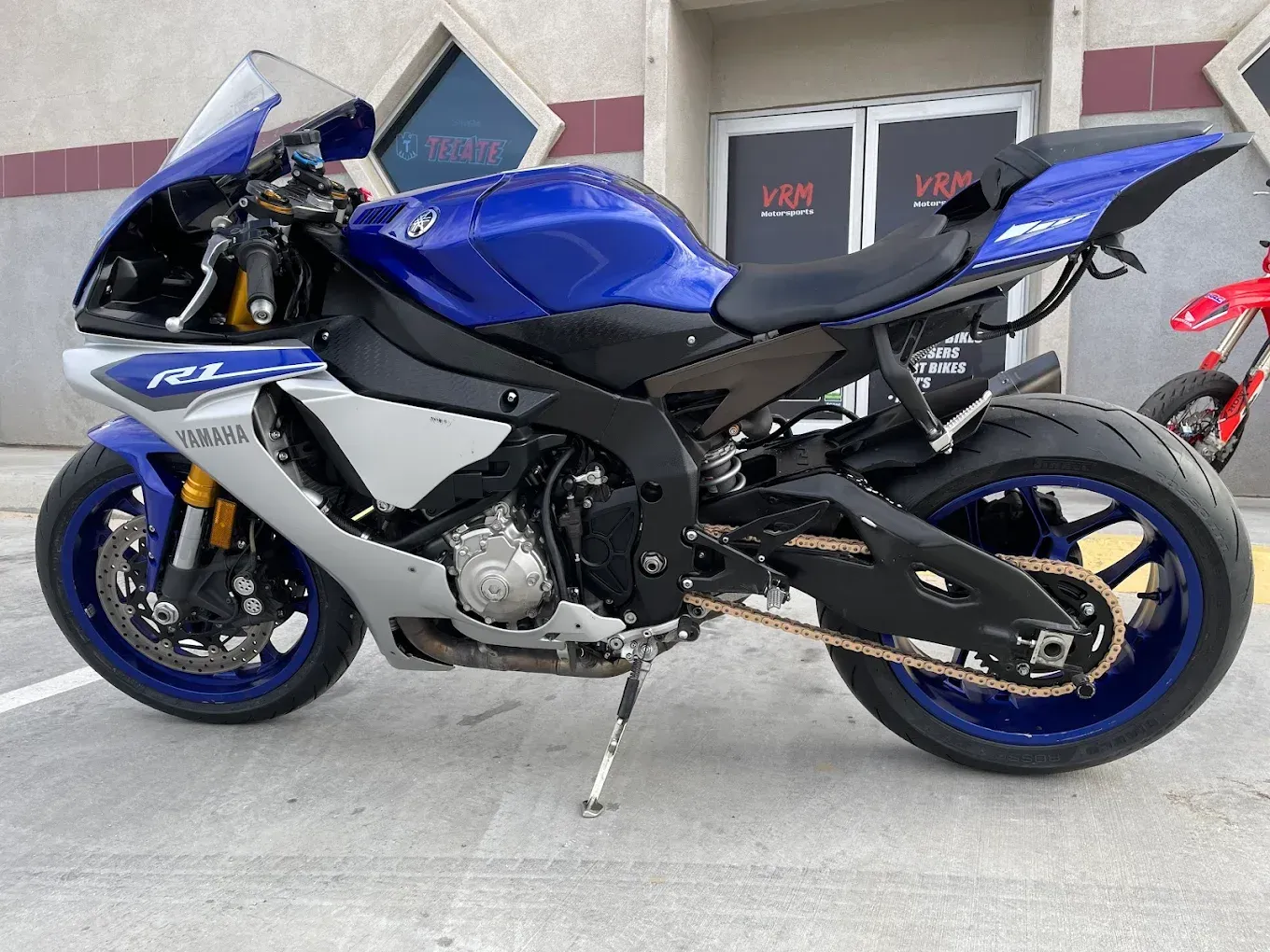 Blue sport motorcycle parked outside a building on a paved surface